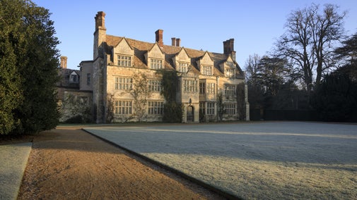 A photo of the frosty lawn in front of the house at Anglesey Abbey. Blue skies.